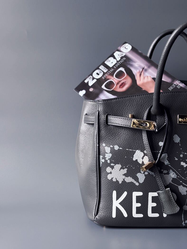 Luxusní designová kožená kabelka Zoi Bag s ručně psaným nápisem "Keep Out" a cákanci barvou. Zapínání pomocí zámku s klíčkem.