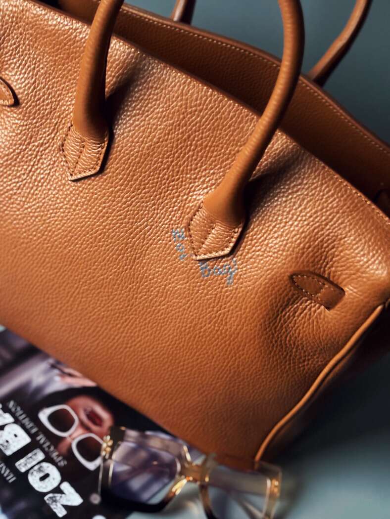 Moderní hnědá kožená kabelka Zoi Bag s nápisem "FCK what they think" zezadu