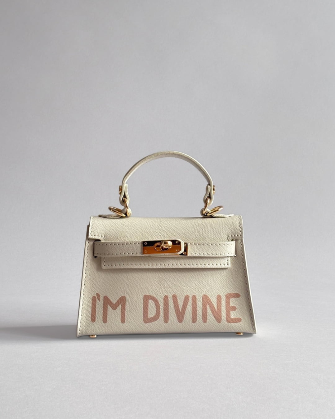 Béžová kabelka Lia od značky Zoibag z italské kůže s autorskou ruční malbou “I’m divine”, pohled zepředu.