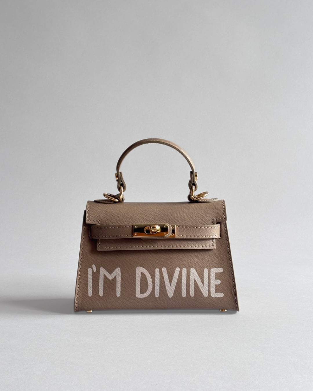 Béžová kabelka Lui z prémiové italské kůže od značky Zoibag s ruční malbou “I’m divine”, pohled zepředu.