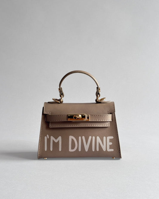 Béžová kabelka Lui z prémiové italské kůže od značky Zoibag s ruční malbou “I’m divine”, pohled zepředu.