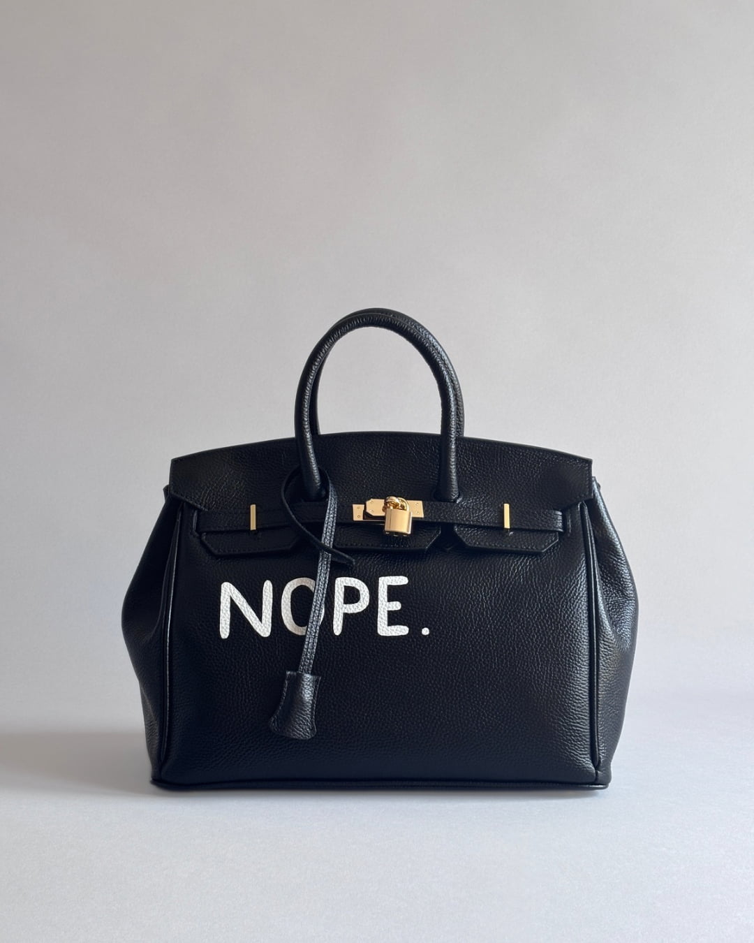 Zapnutá černá kožená kabelka Noi s motivem “Nope” z ateliéru Zoibag, pohled zepředu.
