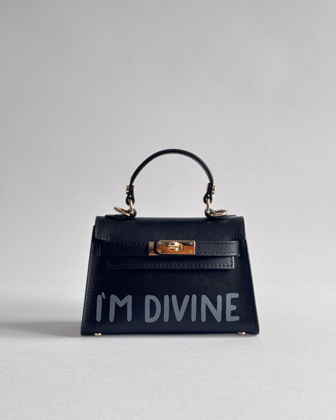 Černá kabelka Nor od značky Zoibag s autorskou ruční malbou “I’m divine”, pohled zepředu.