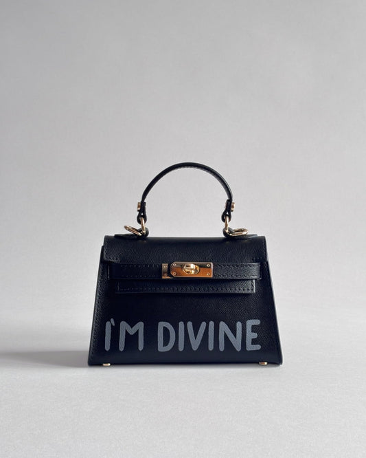 Černá kabelka Nor od značky Zoibag s autorskou ruční malbou “I’m divine”, pohled zepředu.