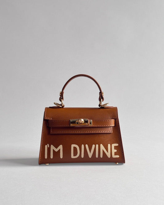 Hnědá kabelka Dao od značky Zoibag s ruční malbou “I’m divine” z italské kůže, pohled zepředu.