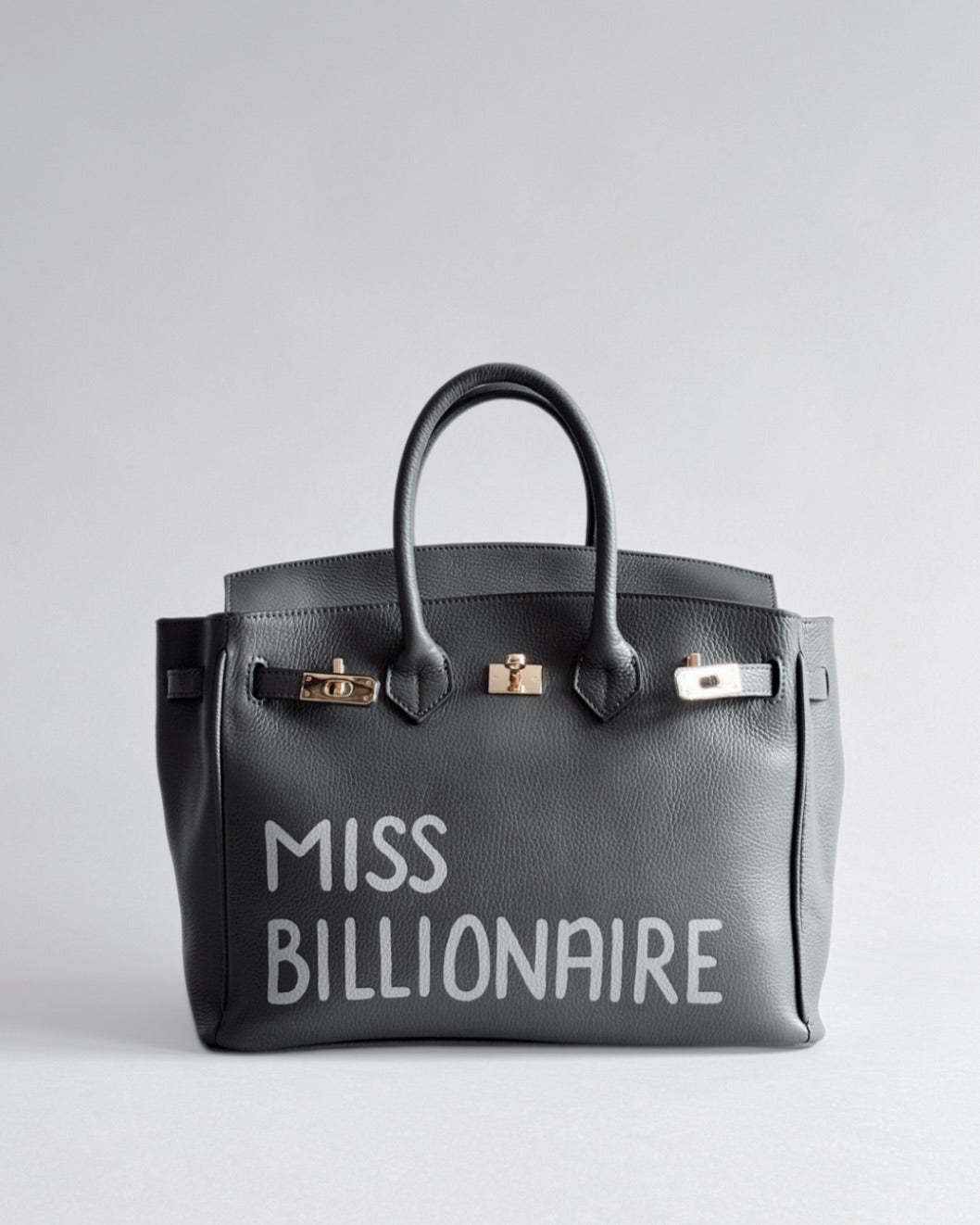 Šedá kabelka Moi z pravé italské kůže od značky Zoibag s ruční malbou “Miss Billionaire”, pohled zepředu.