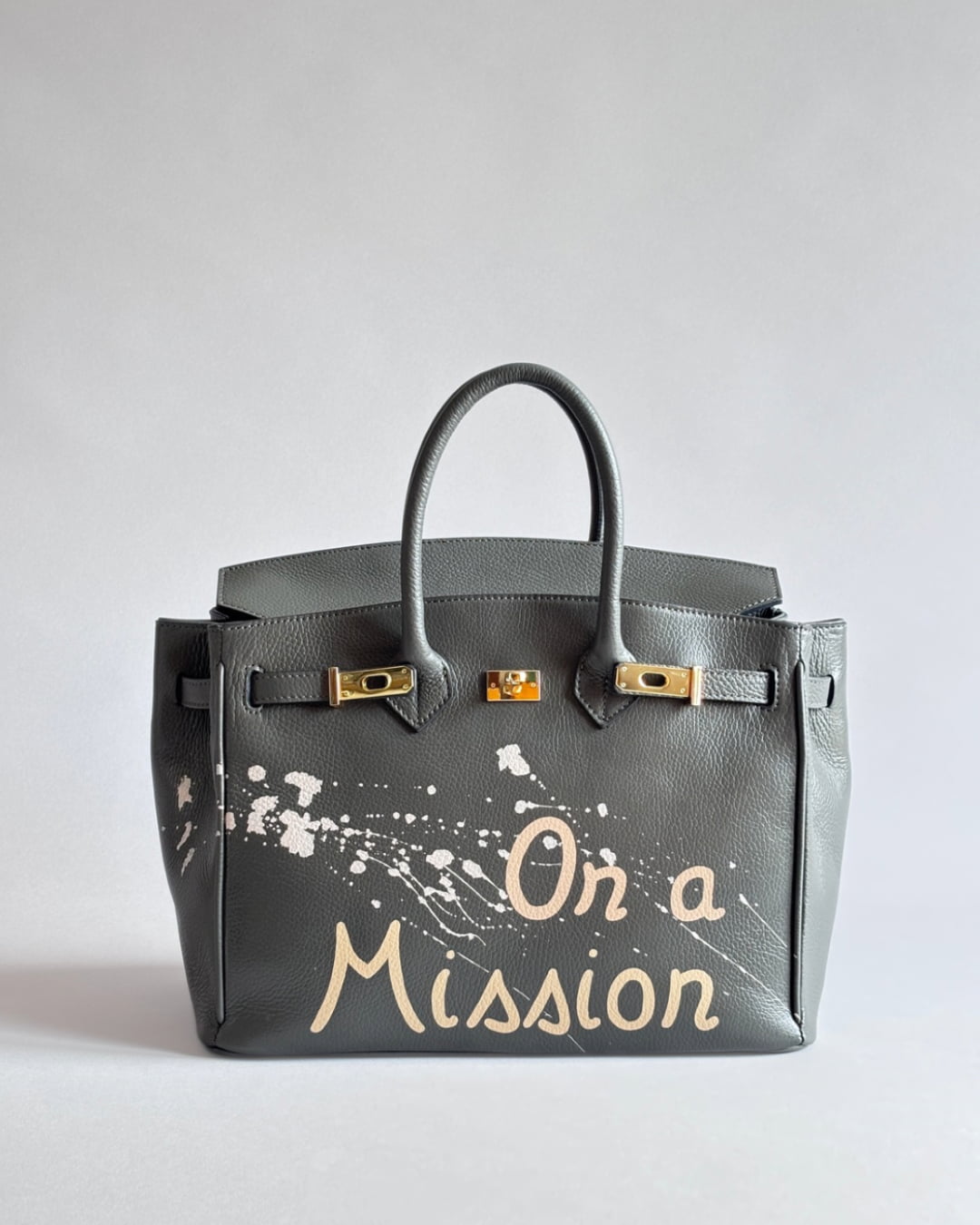Šedá kabelka Nel s unikátní ruční malbou “On a Mission” od značky Zoibag z italské kůže, pohled zepředu.